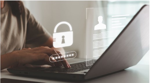 Photo of a person working on a laptop with lock and profile icons hovering above it.